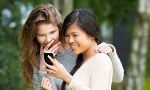 2 girls looking at a cellphone